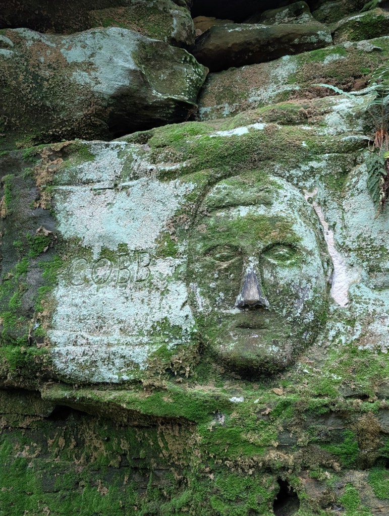 A face carved into the stone with the word "COBB" next to it.