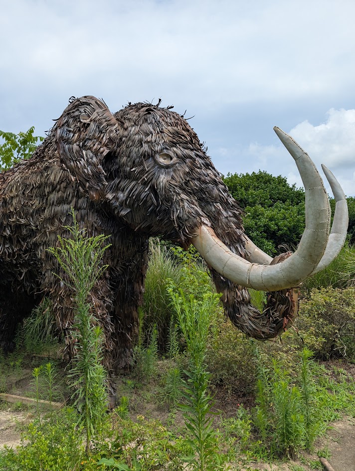 A very large metal statue of a mammoth.