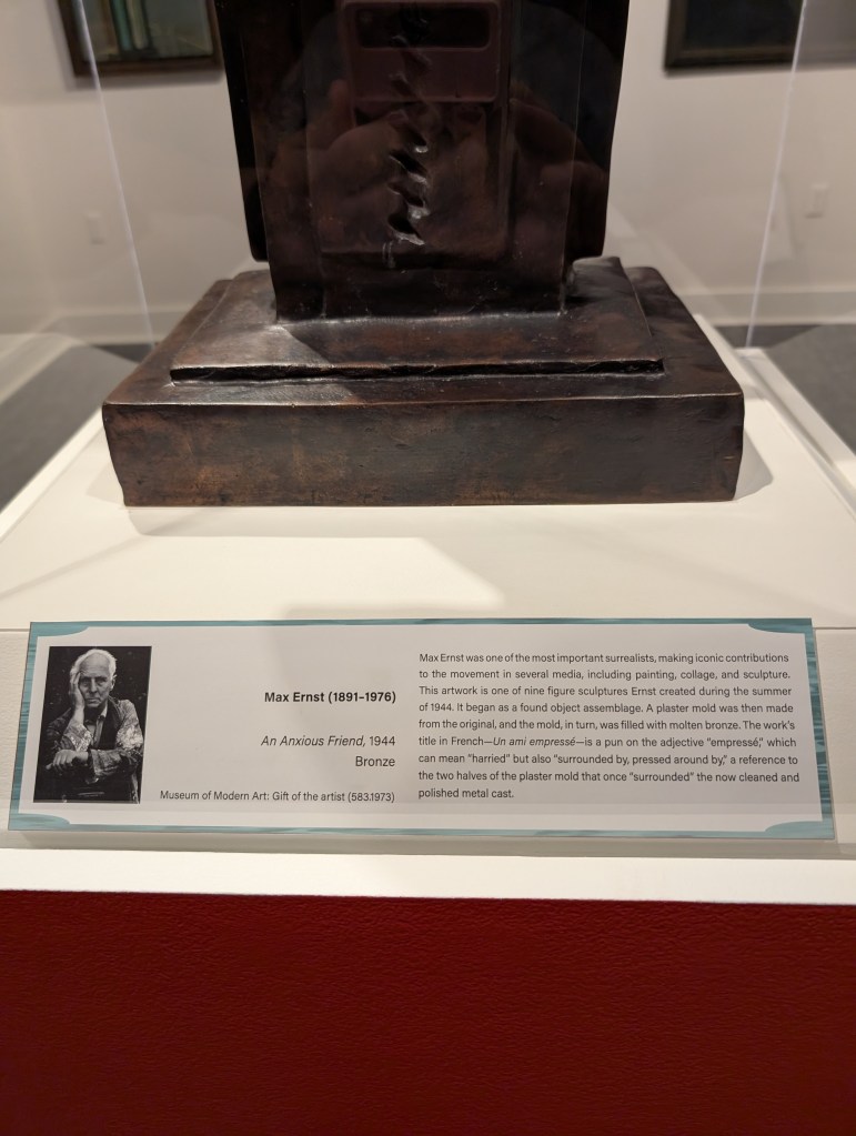 A plaque that says the art is called "An Anxious Friend" and was made in 1944 by Max Ernst.