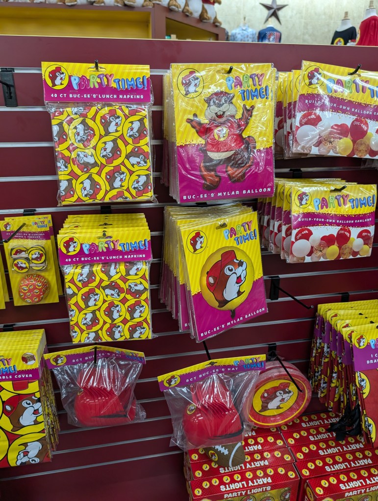 A wall full of party decorations for a Bucc-ee's part, including napkins, balloons, and party lights